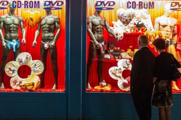 Eine Frau und ein Mann vor dem Schaufenster eines Sexshops