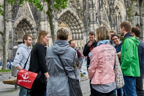 Einige Leute stehend in einem Kreis mit Tourguide