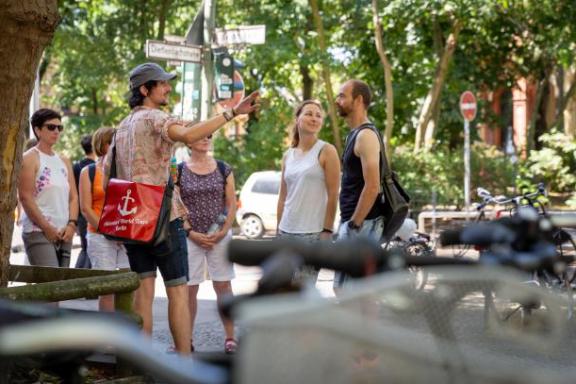 Ein Tourguide mit einer Tourgruppe im Sommer