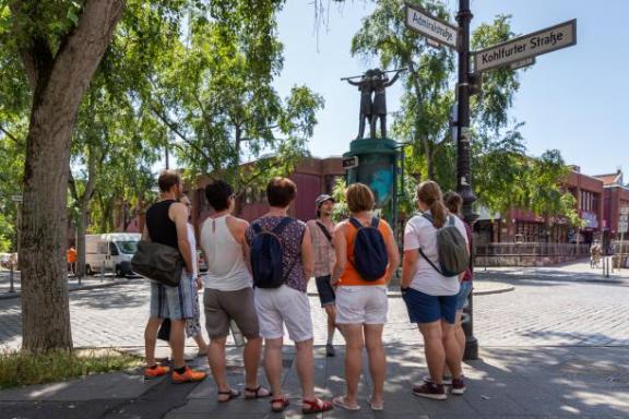 Ein Tourguide mit einer Tourgruppe im Sommer