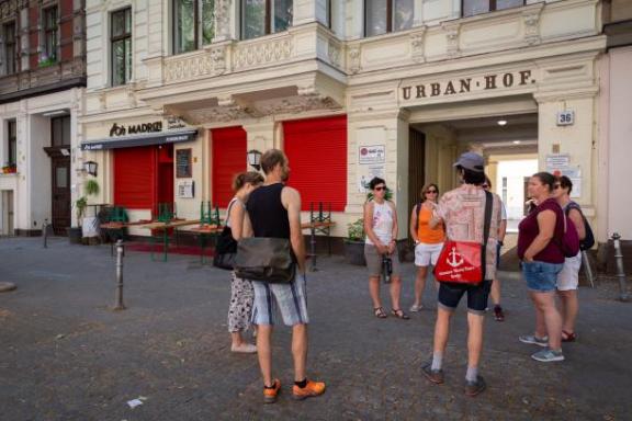 Ein Tourguide mit einer Tourgruppe im Sommer