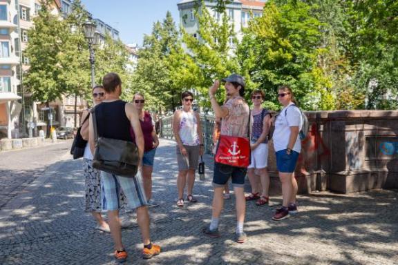 Ein Tourguide mit einer Tourgruppe im Sommer