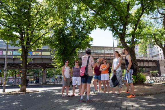 Ein Tourguide mit einer Tourgruppe im Sommer
