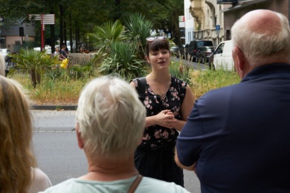 Eine Frau erzählt einer Tourgruppe vor ihr etwas