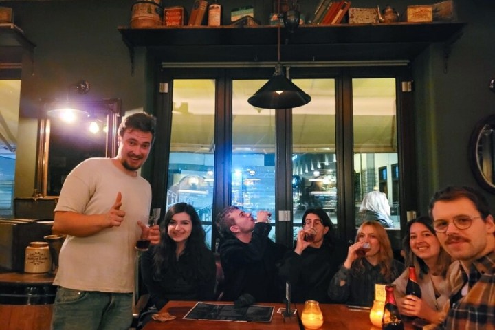 a group of people standing around a table posing for the camera
