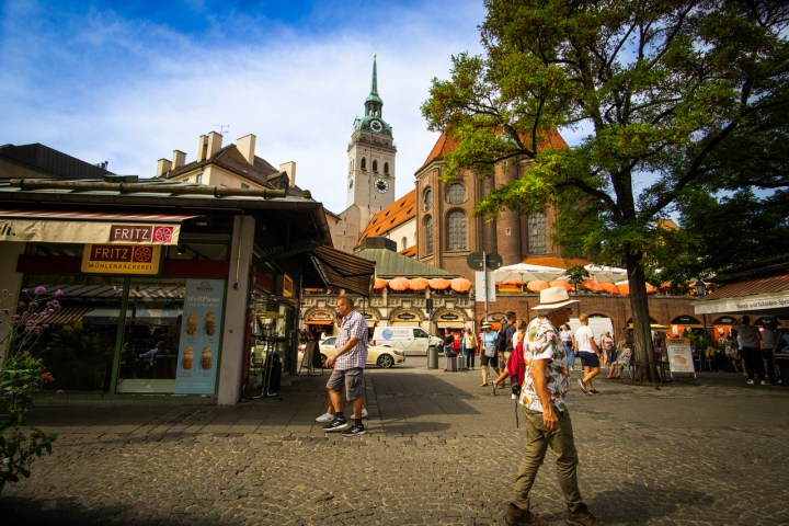 a group of people walking down a street in front of a building
