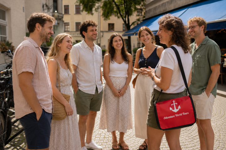 Group of people smiling outdoors, one carrying a red bag.