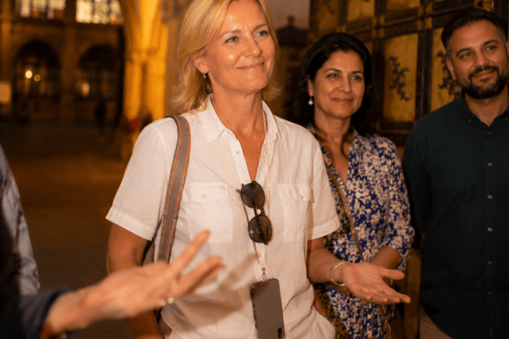 Group of people smiling inside a historic building with vaulted ceilings.