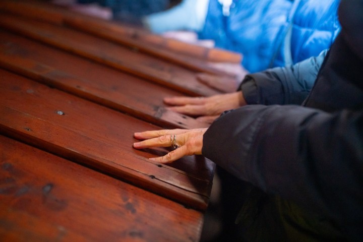 a man sitting on top of a wooden cutting board