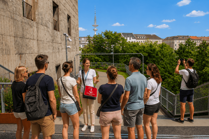 Group on a rooftop tour with a guide, cityscape and TV tower in the background.